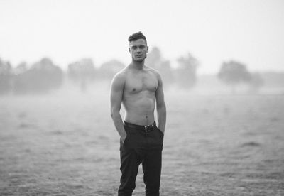 Portrait of shirtless man standing on land