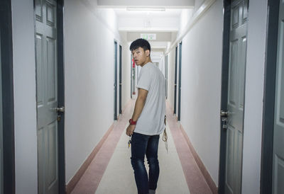 Portrait of young man standing in corridor of building