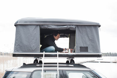 Man working in a tent with a view to social distance from the office