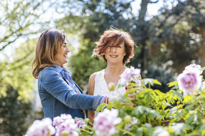 Happy mature female friends in blooming garden