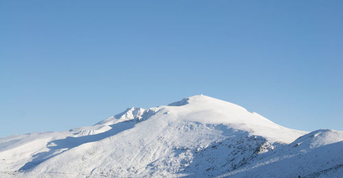 Scenic view of snowcapped mountains against clear blue sky