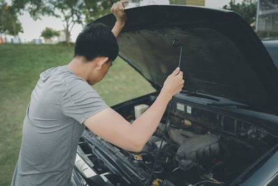 Side view of man holding car