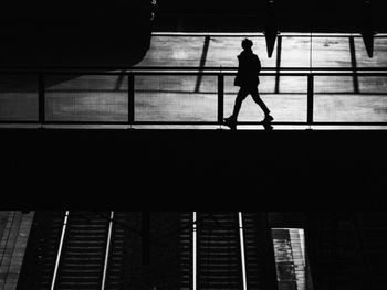 Silhouette woman walking on escalator