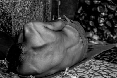 Shirtless homeless man sleeping in city