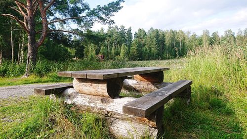 Wooden structure on field against trees in forest