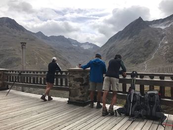 People on mountain against cloudy sky