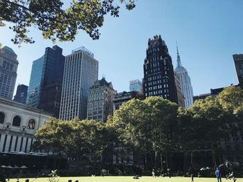 Low angle view of trees and buildings against clear sky