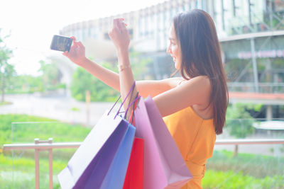 Midsection of woman photographing with mobile phone