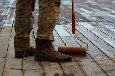 Low section of man mopping floorboard