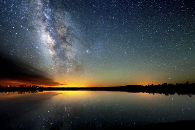 Scenic view of lake against sky at night