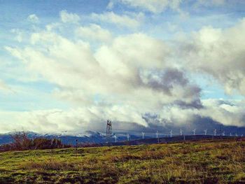 Scenic view of grassy field against cloudy sky