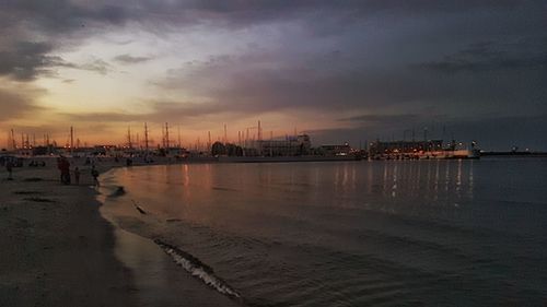 Scenic view of sea against cloudy sky at sunset