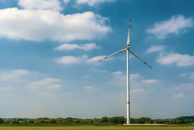 Windmill on field against sky