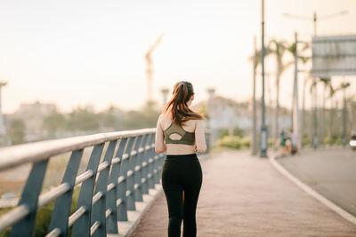 Full length of woman standing on bridge