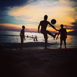 Children playing on beach at sunset