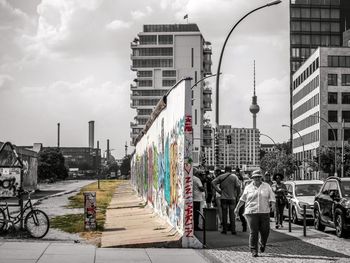 People on street against buildings in city