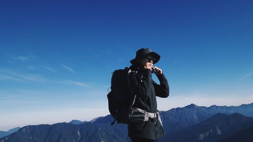 Man standing on snowy mountain against sky