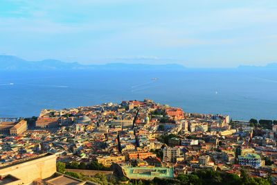 High angle view of city by sea against sky