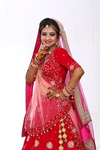 Woman standing against pink background