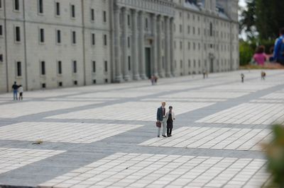 People walking on footpath in city