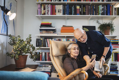 Senior couple using mobile phone at home