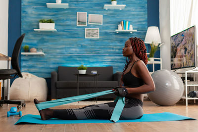 Side view of woman sitting on floor