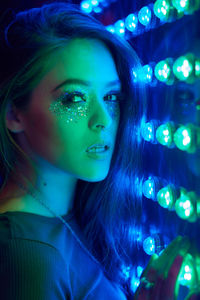 Close-up portrait of young woman with glitter make-up