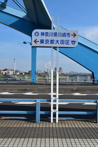 Road sign against sky in city