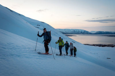 People on snowcapped mountain against sky