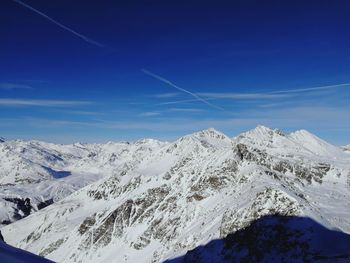 Scenic view of snowcapped mountains against blue sky