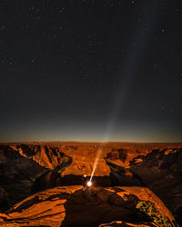 Scenic view of illuminated field against sky at night