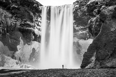 Mid distance of man standing against waterfall