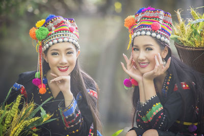 Smiling females in traditional clothing sitting outdoors