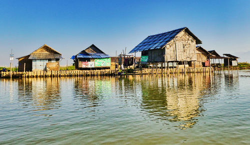 Houses by building against clear sky