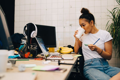 Young woman sitting on table