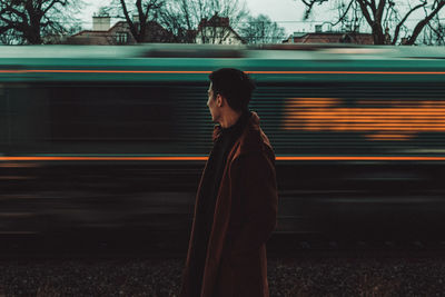 Rear view of man standing on railroad track