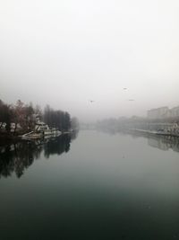 Scenic view of lake in foggy weather against sky