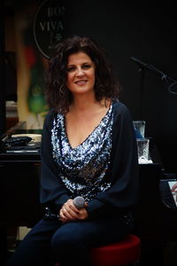 Portrait of smiling woman sitting on stool