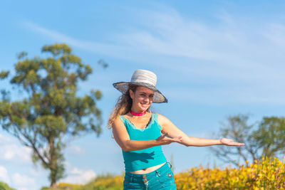 Woman wearing hat standing against sky