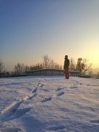 Man on snow covered landscape against clear sky