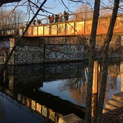 Bridge over river in city against sky