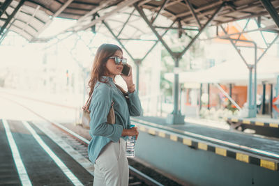 Portrait of young woman standing in city