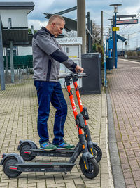 Man standing on footpath in city