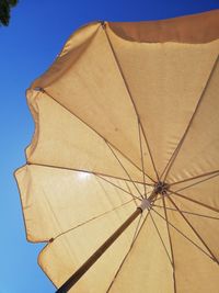 Low angle view of umbrella against blue sky