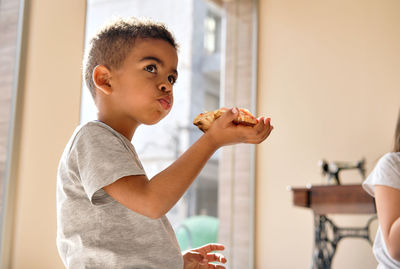 Portrait of boy holding camera at home