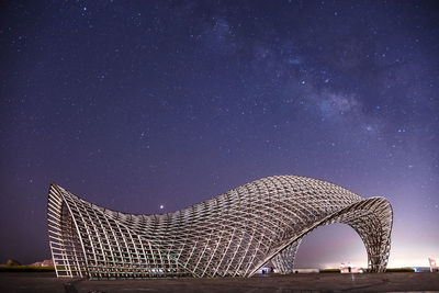 Low angle view of illuminated bridge against sky at night