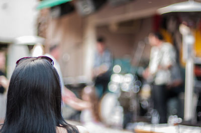 Rear view of woman with performance group playing music in background