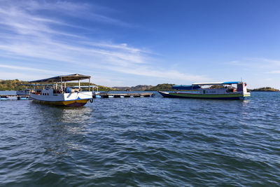 Boats sailing in sea against blue sky