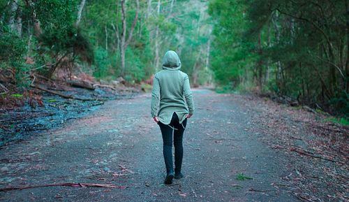 Rear view of woman walking in forest