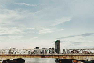 Bridge over river against cloudy sky